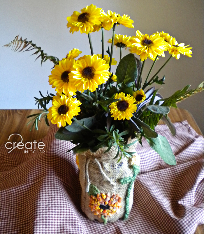 Celebrate autumn with sunflowers! My locker-hooked burlap panel turns a canning jar into a seasonal vase.